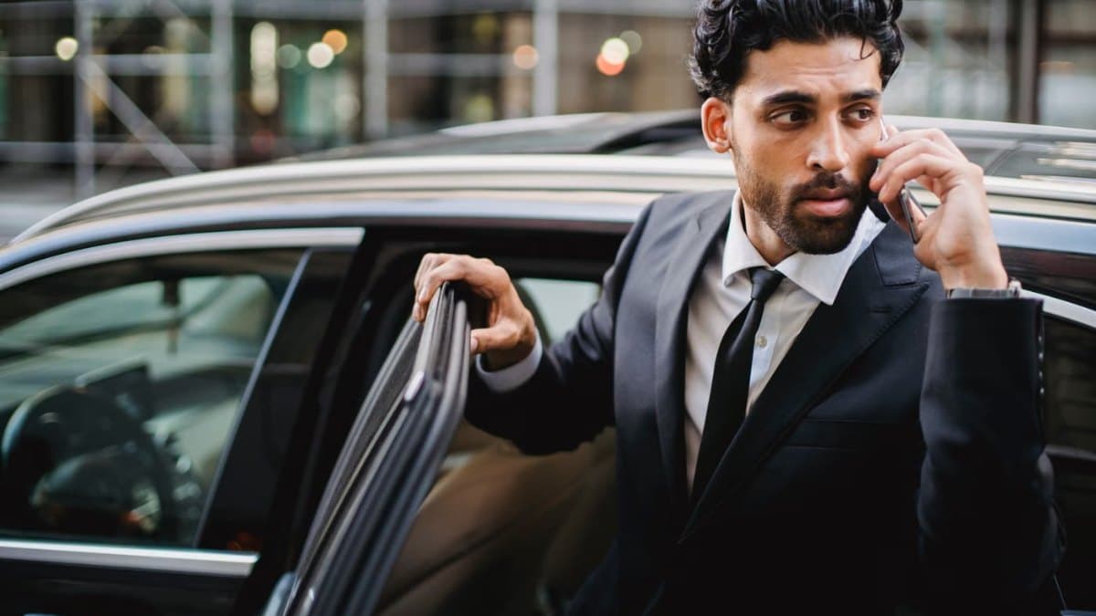 Businessman in a suit stepping out of a chauffeured car in downtown Toronto