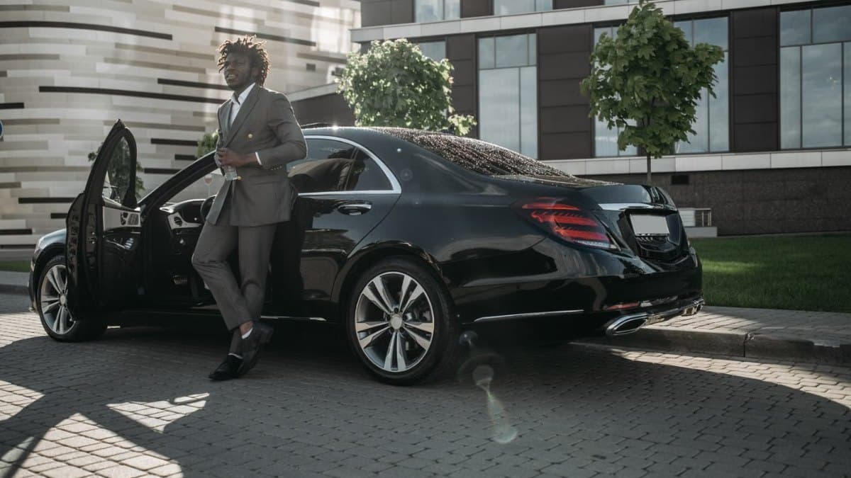 Businessman in a suit stepping out of a luxury car outside a Toronto hotel