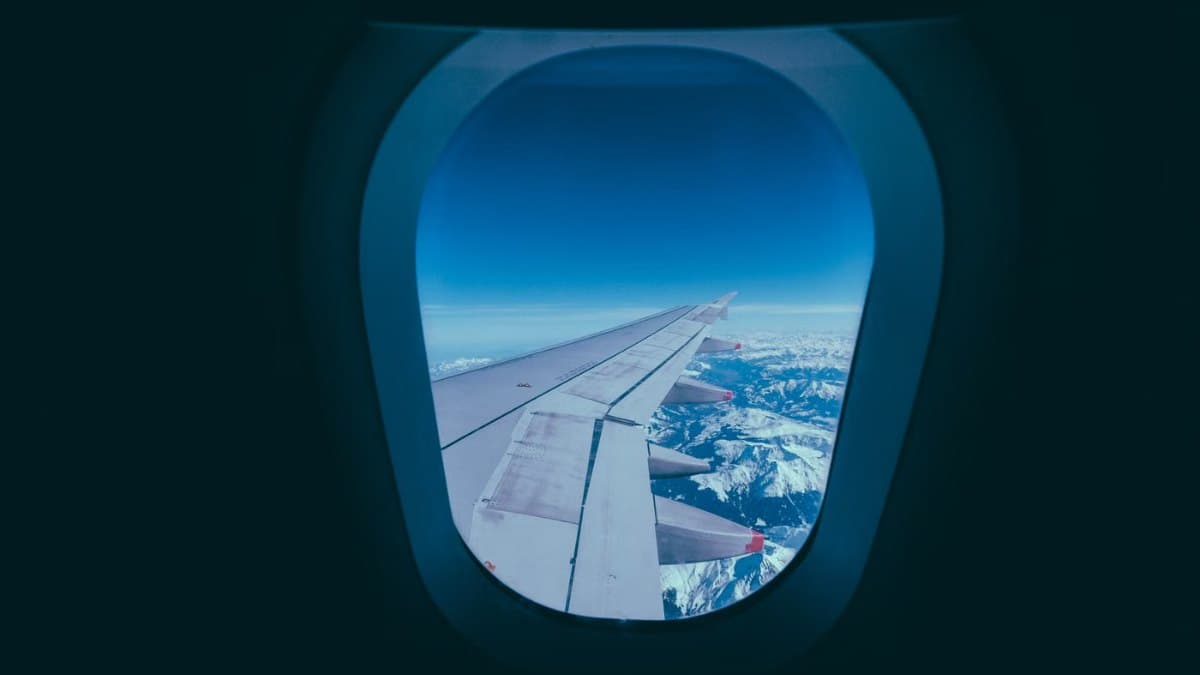 View of a snowy mountain landscape from an aircraft window