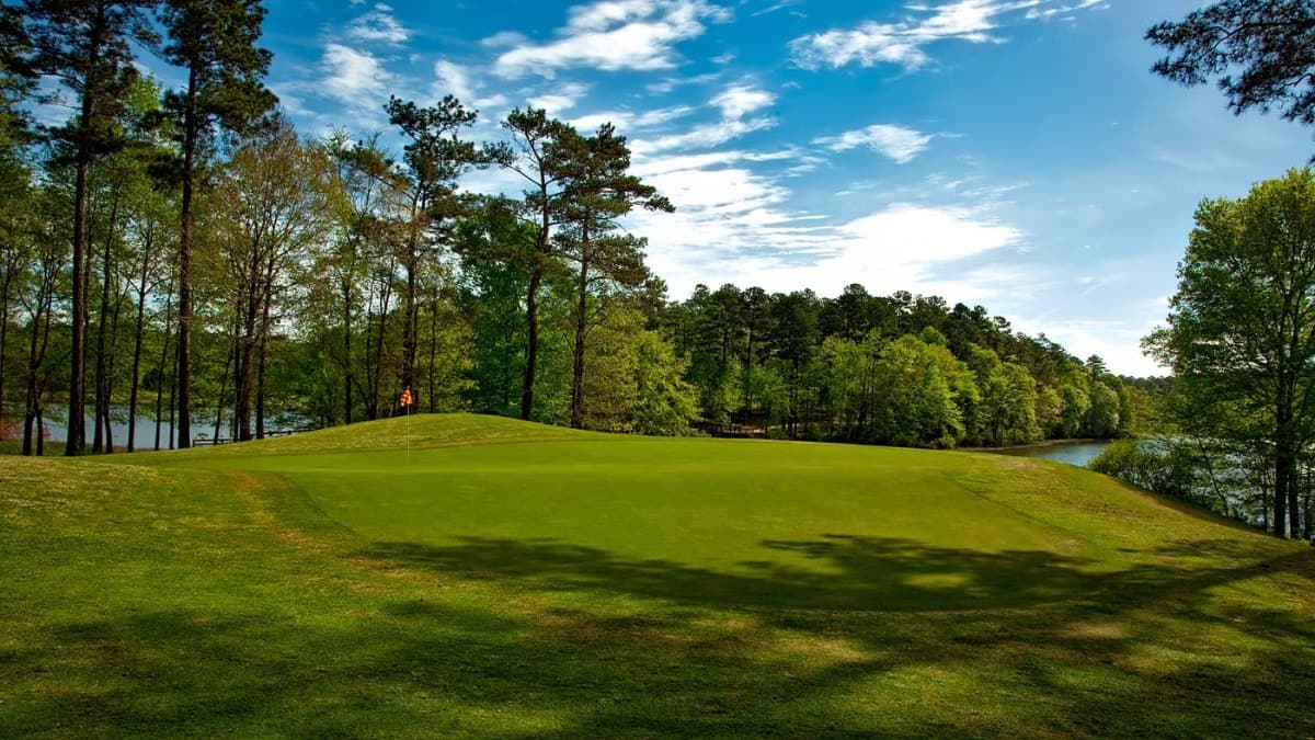 Manicured golf course fairway surrounded by trees and water
