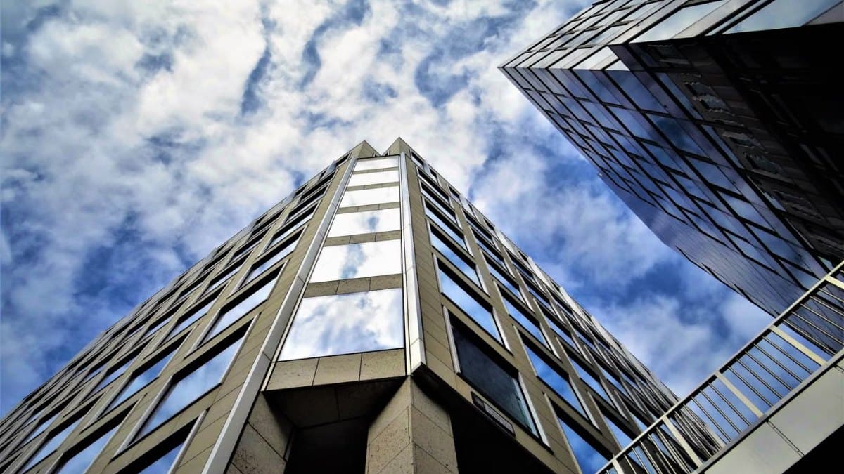 Low angle view of a modern glass skyscraper reflecting the sky