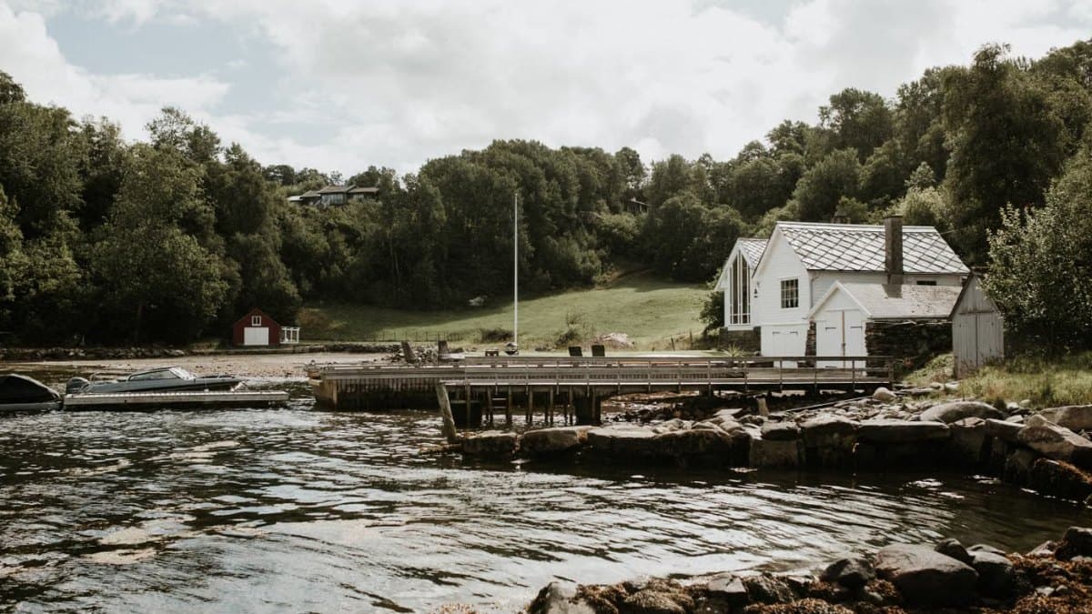 Peaceful lakeside scene with a dock, moored boats and greenery
