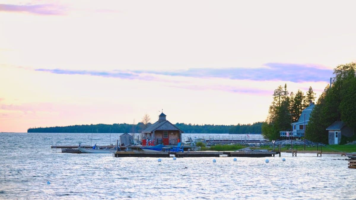Beautiful sunset over a tranquil lake with a pier and moored boats