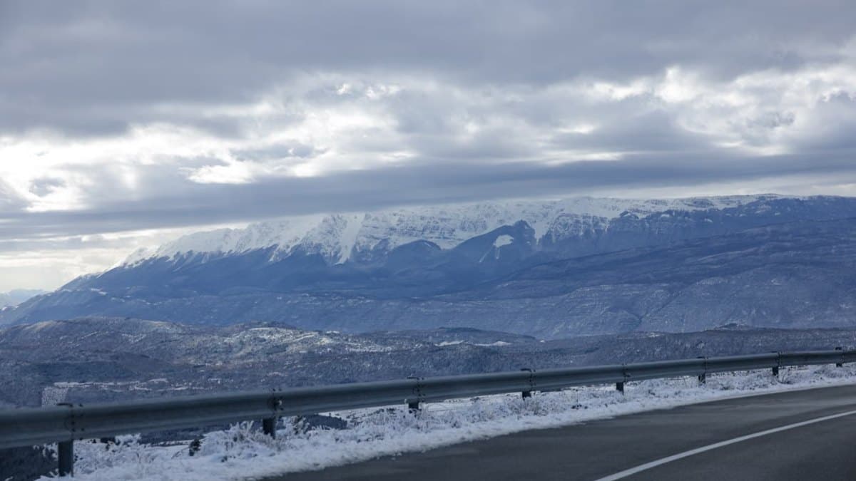 A winding country road running between snow-dusted hills