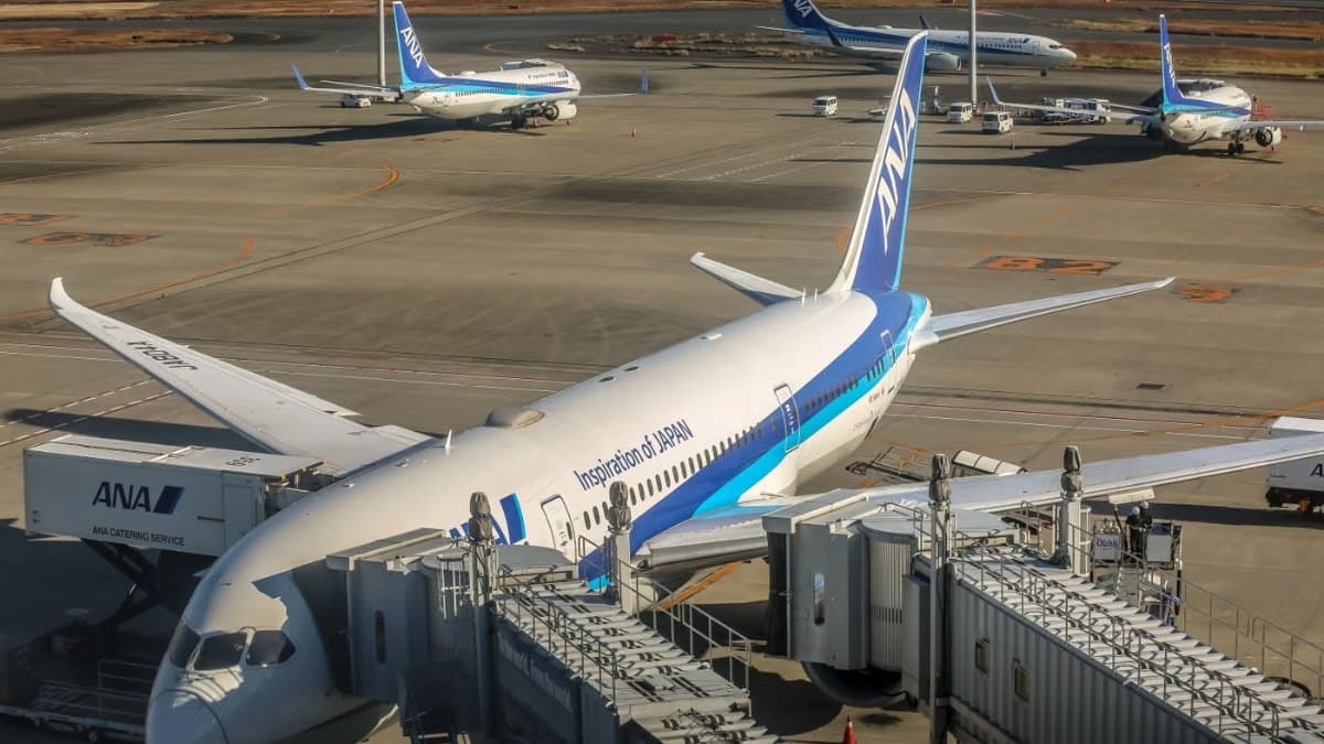 Aircraft parked at an airport terminal gate with a jet bridge