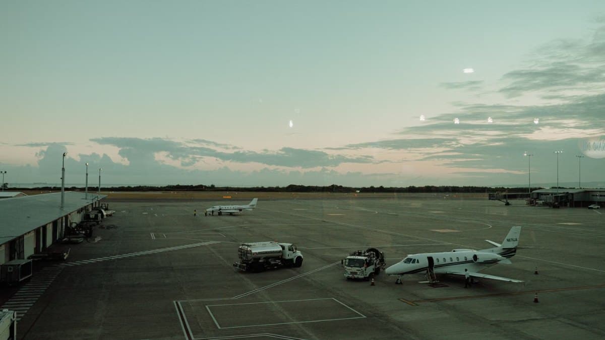 Private jets and ground service vehicles on an airport tarmac