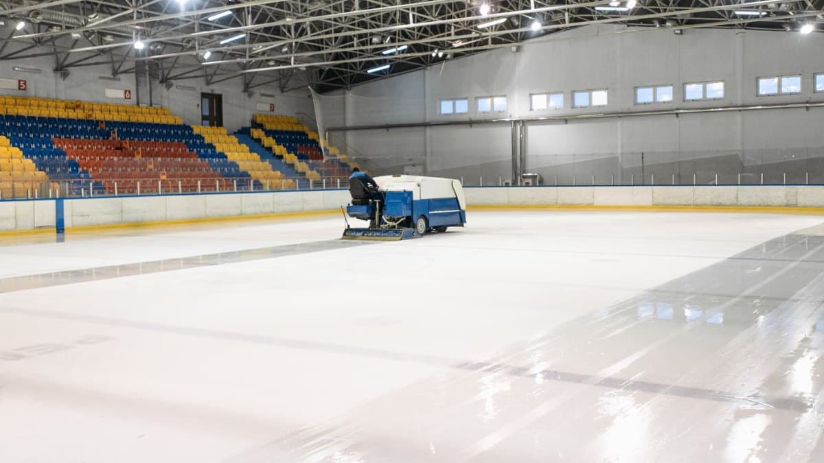 Ice resurfacer smoothing the surface of an indoor ice rink