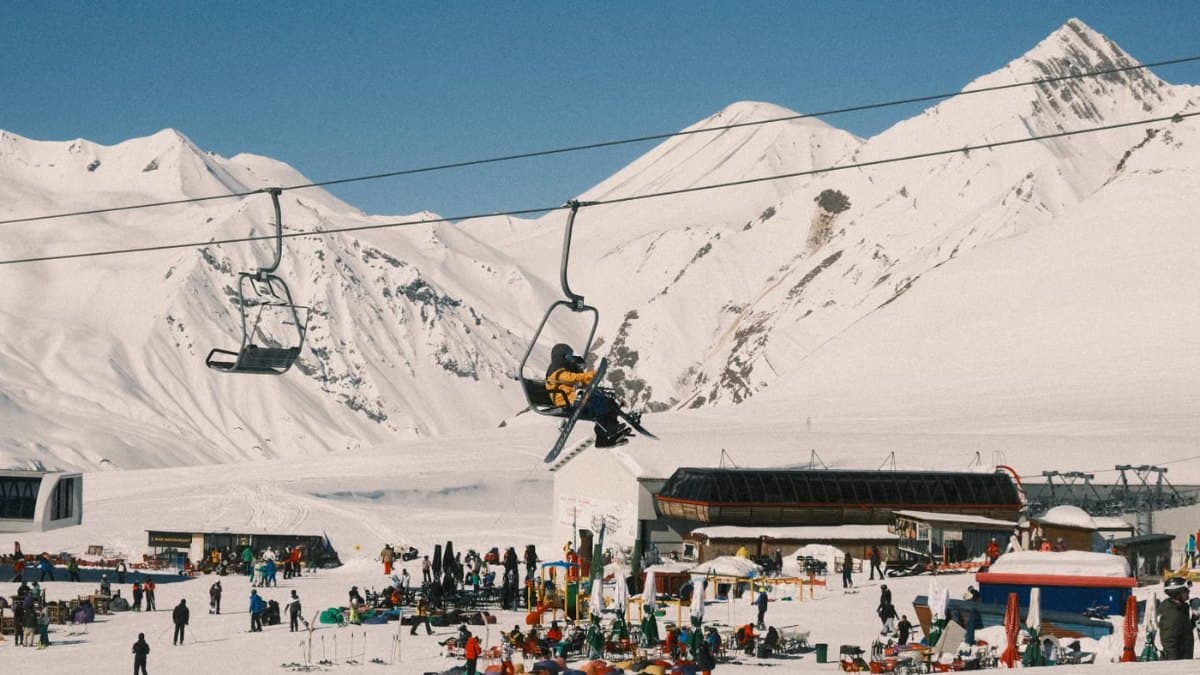 Ski resort scene with chairlift and snowy mountains