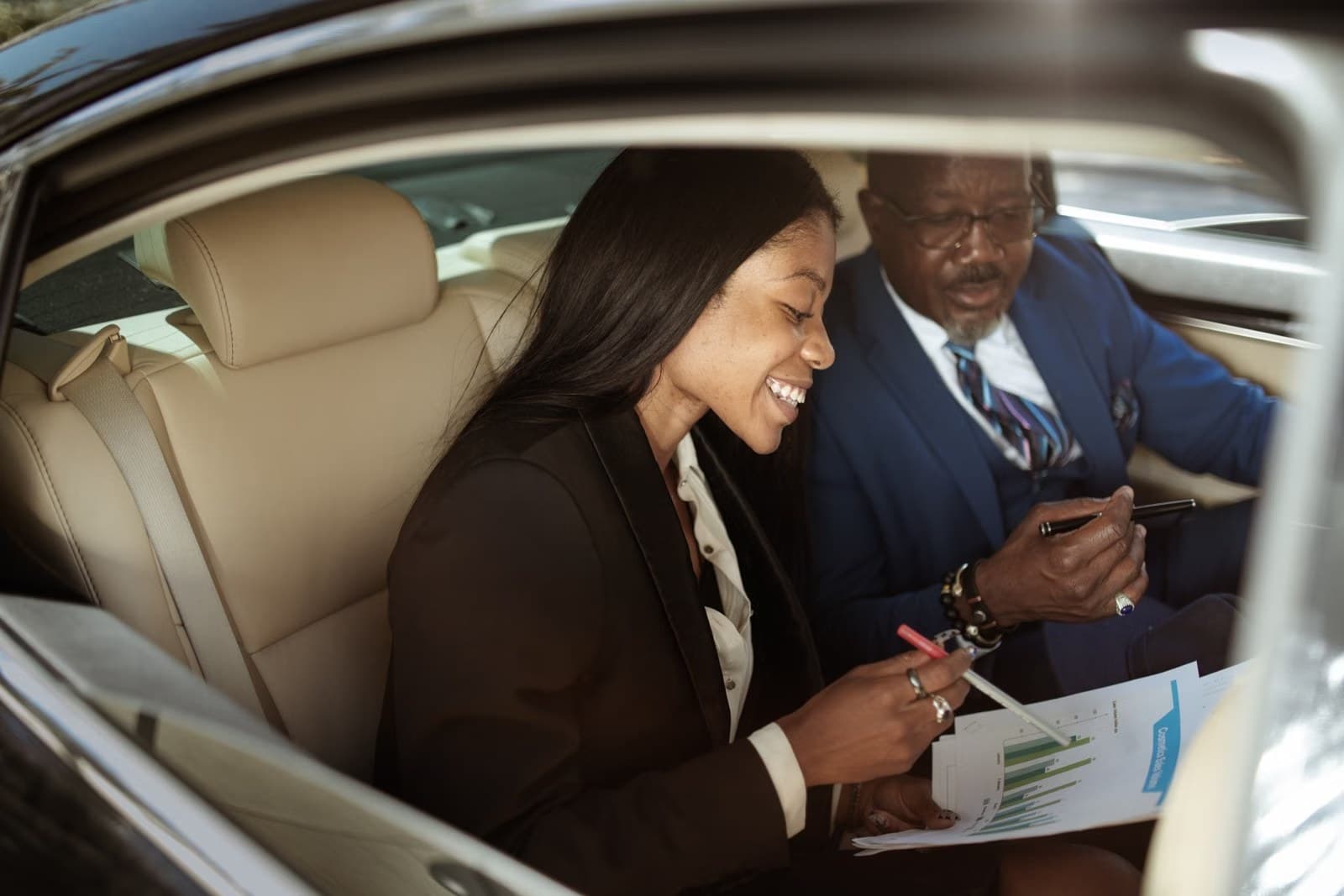 Two business professionals in discussion inside a car