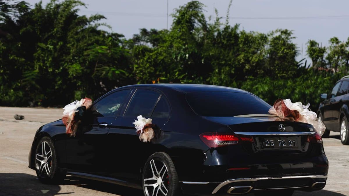 Black wedding car decorated with ribbons and flowers outside a Toronto venue