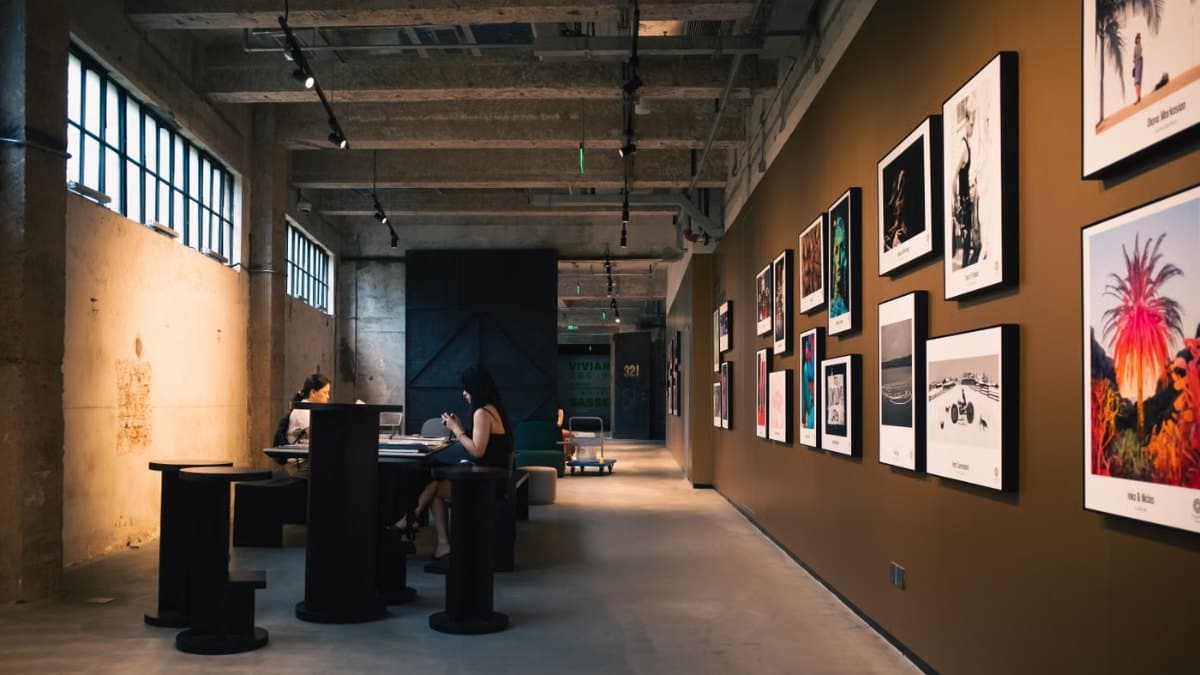 Art gallery hallway with framed artworks and seated visitors